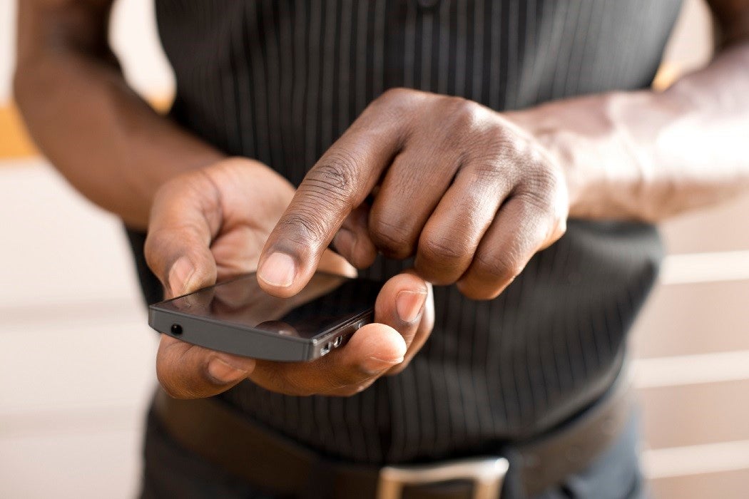 Close-up of individual tapping a smart phone