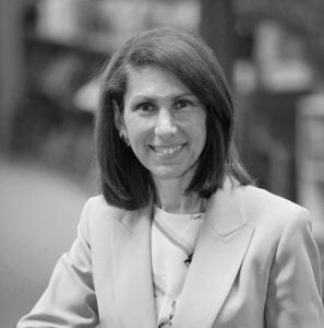 Black and white headshot of author Amy Handlin against a blurred background