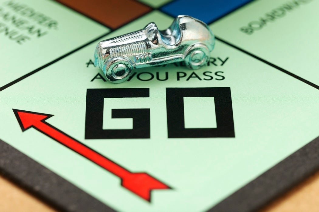 The car token at the starting square of the Monopoly board game