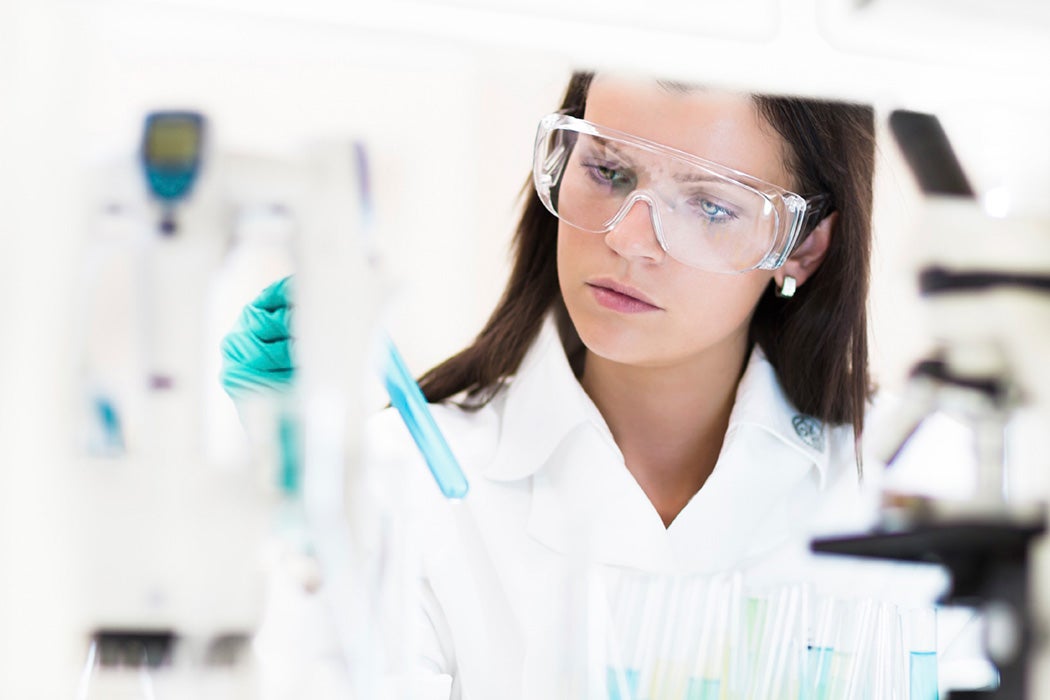 A chemist looks at a test tube in a medical lab