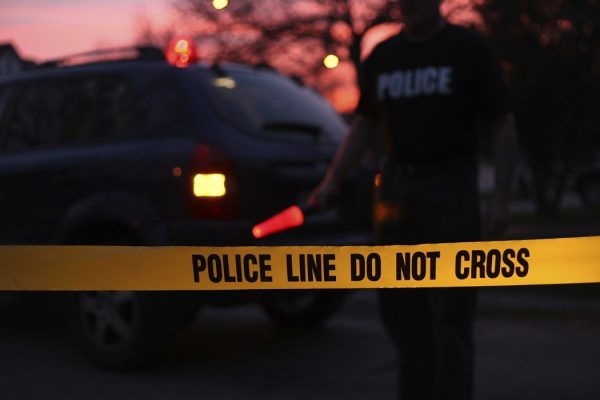 Police officer directing traffic behind a Do Not Cross line