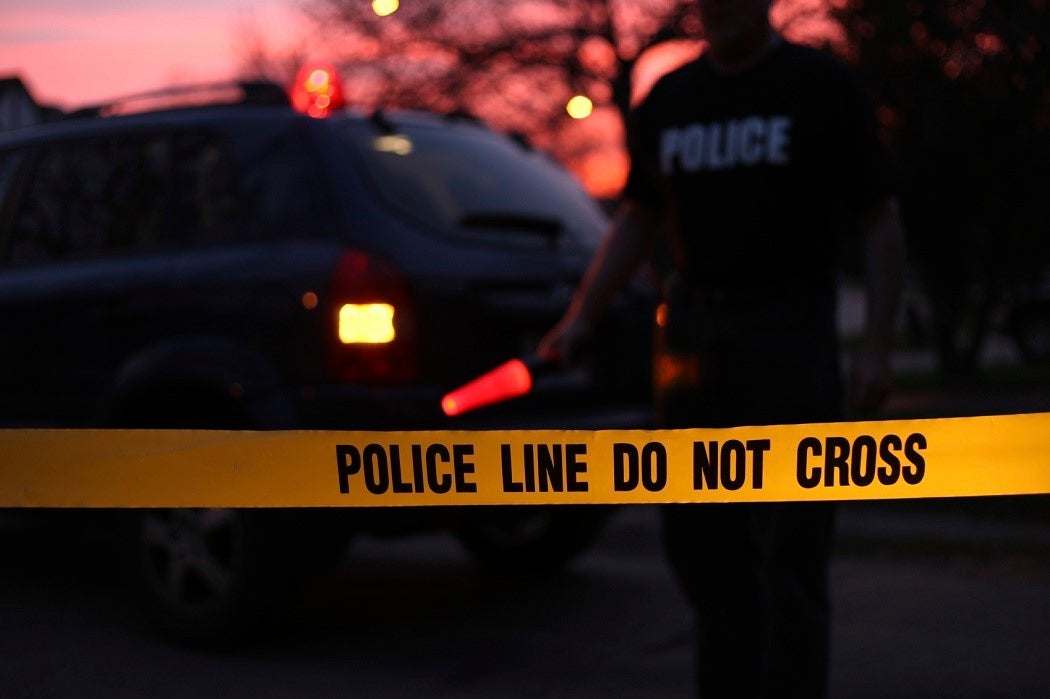 Police officer directing traffic behind a Do Not Cross line