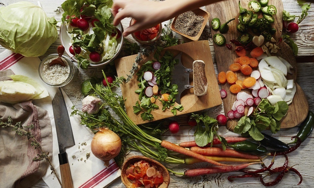 A kitchen table full of chopped vegetables and spices