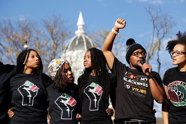 Concerned Student 1950, led by University of Missouri graduate student Jonathan Butler, second from right, speaks following the announcement that University of Missouri System President Tim Wolfe would resign Monday, Nov. 9, 2015, in Columbia, Mo. Wolfe resigned Monday with the football team and others on campus in open revolt over his handling of racial tensions at the school. (Sarah Bell/Missourian via AP)