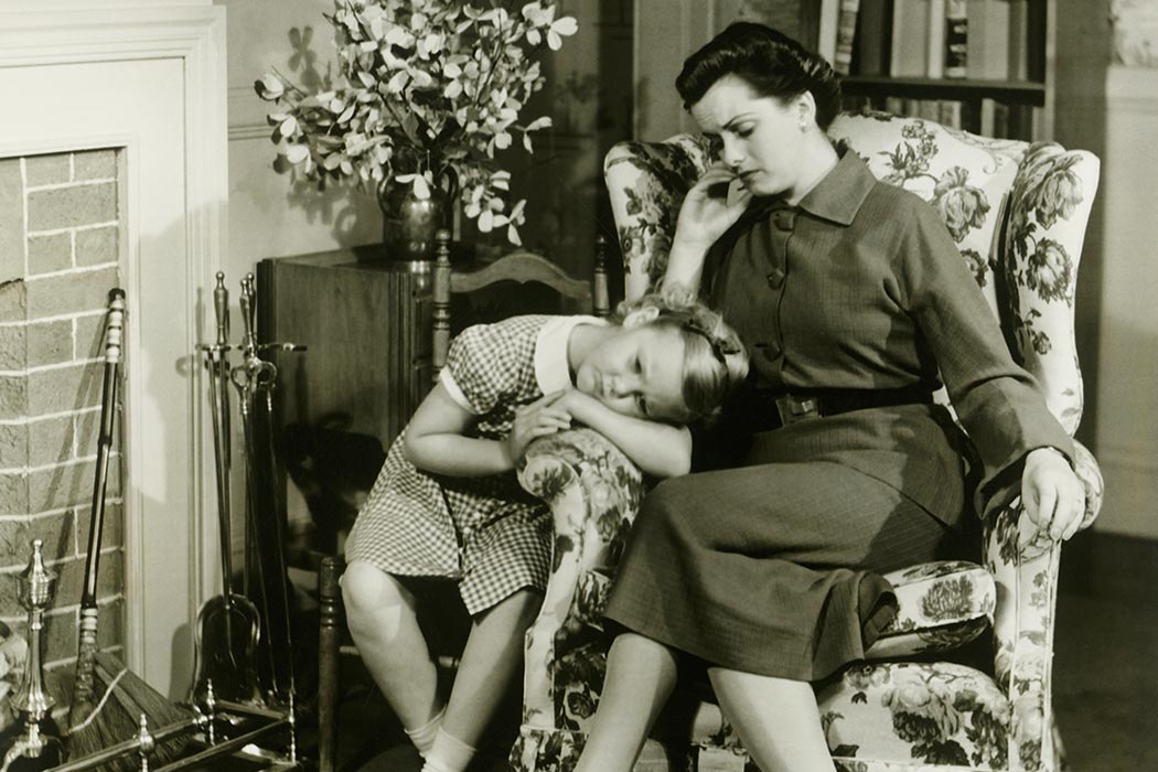 A mother and daughter sitting in the living room together.