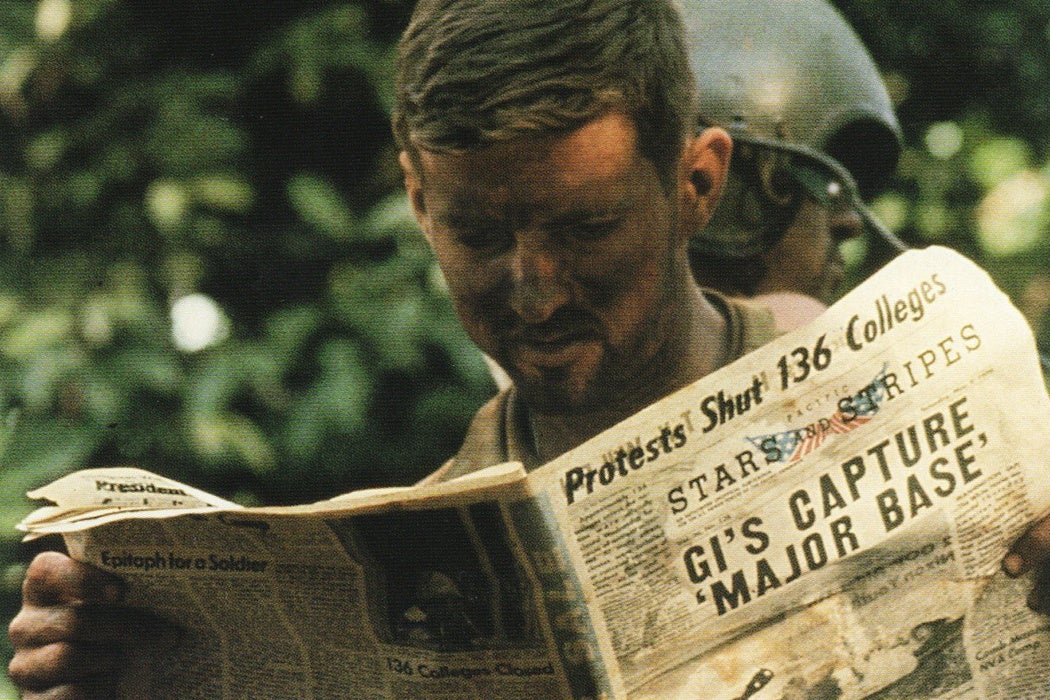 Soldier reading newspaper