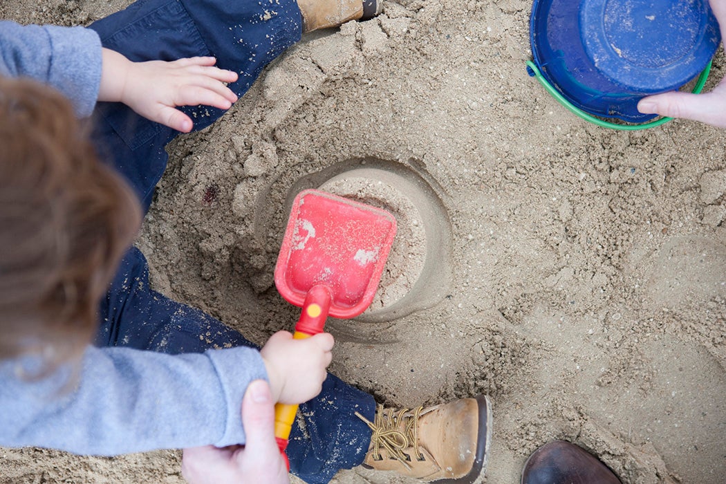 Toddler boy playing in sandbox