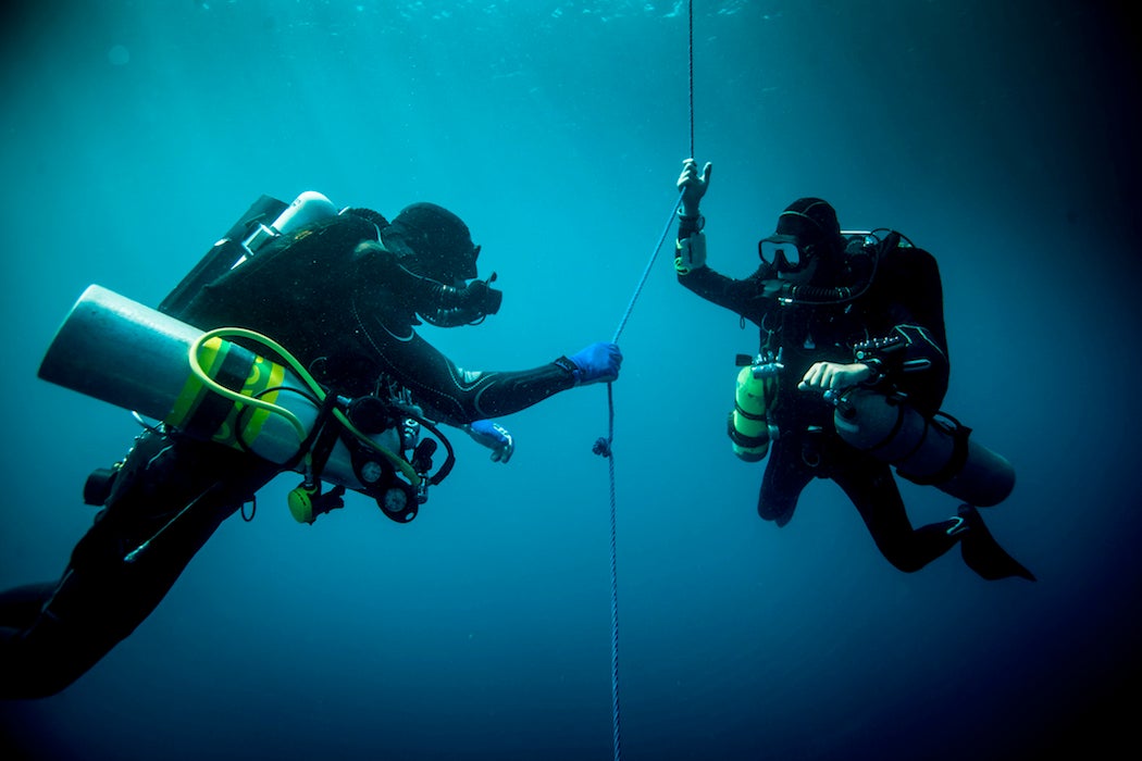 Underwater view of two technical divers using rebreathers device to locate shipwreck, Lombok, Indonesia