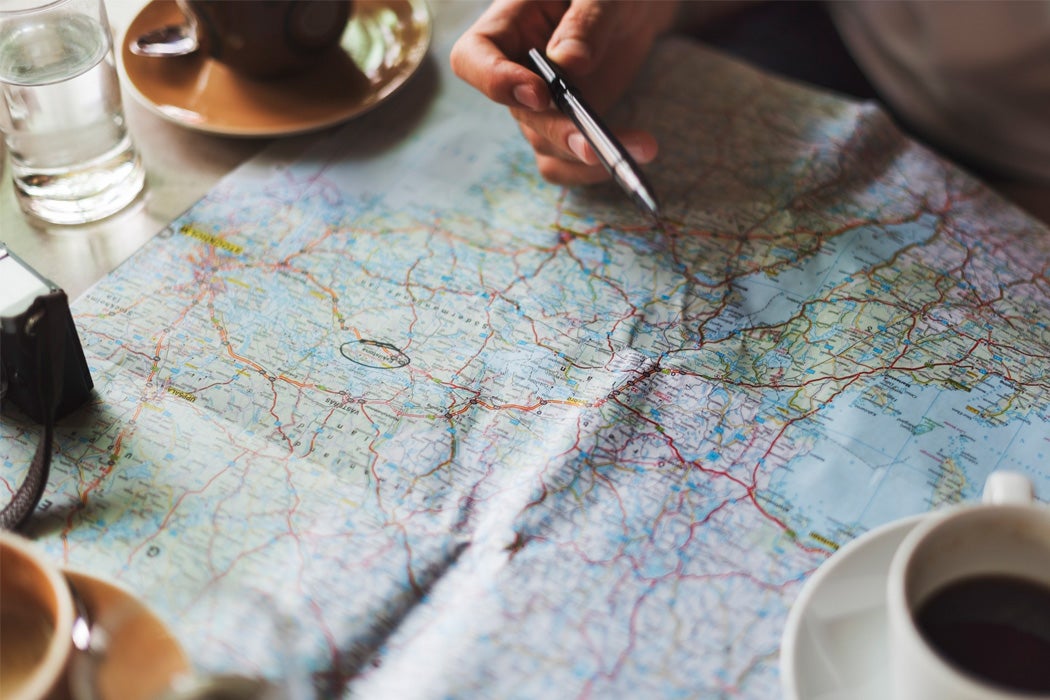 A person looking at a map, holding a pen