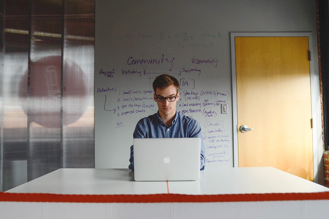 A man sitting in an office with a computer.