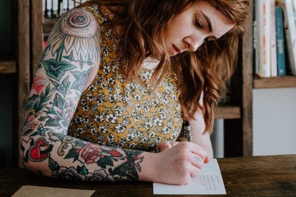 A woman writing a letter at a table