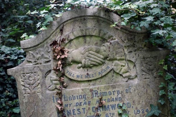 A headstone featuring clasped hands