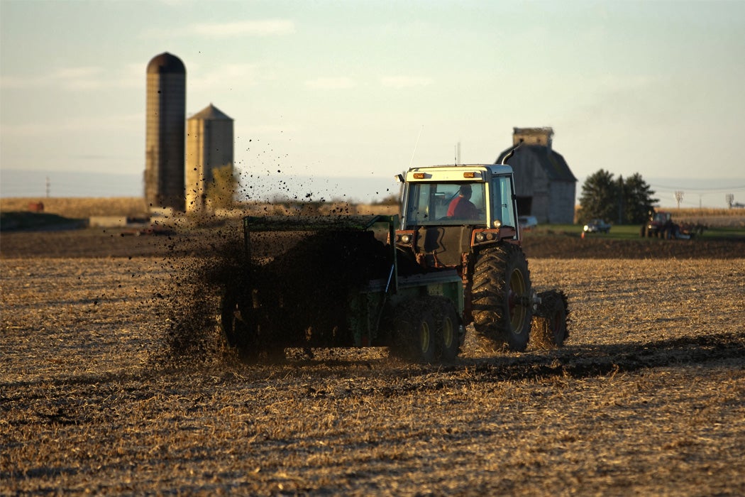 A tractor spreads biosolids in a field