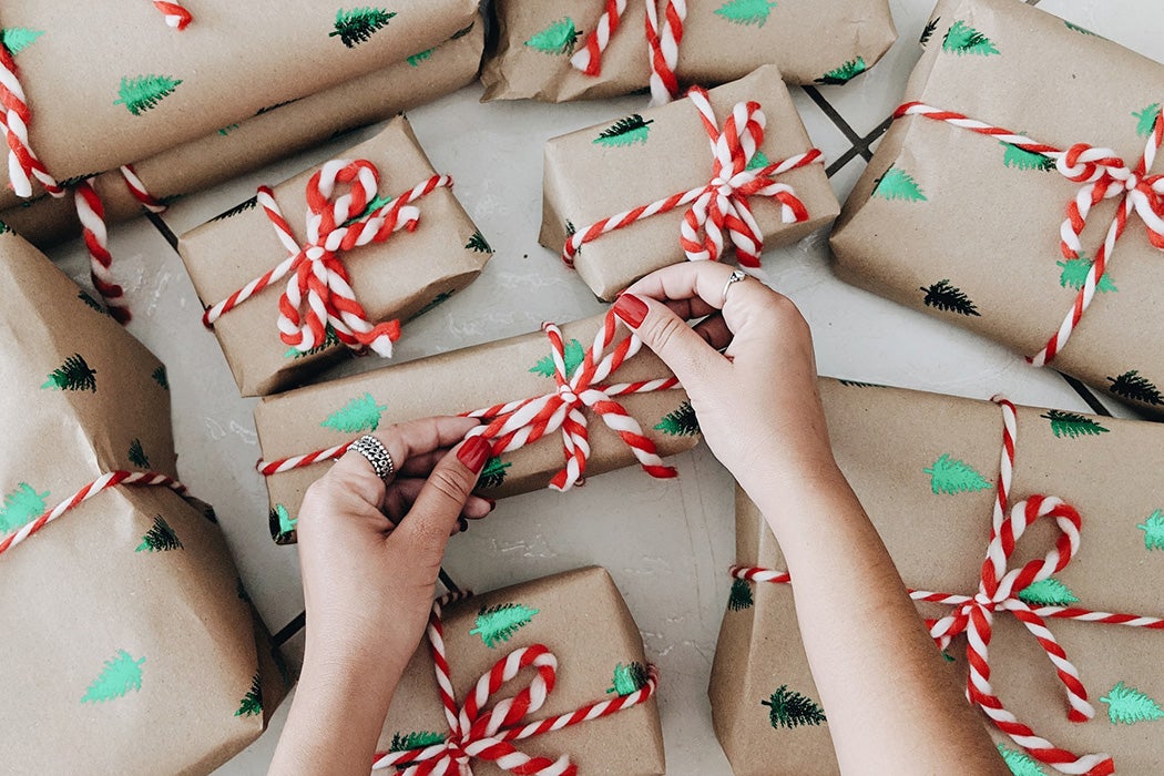 A person's hands wrapping Christmas gifts