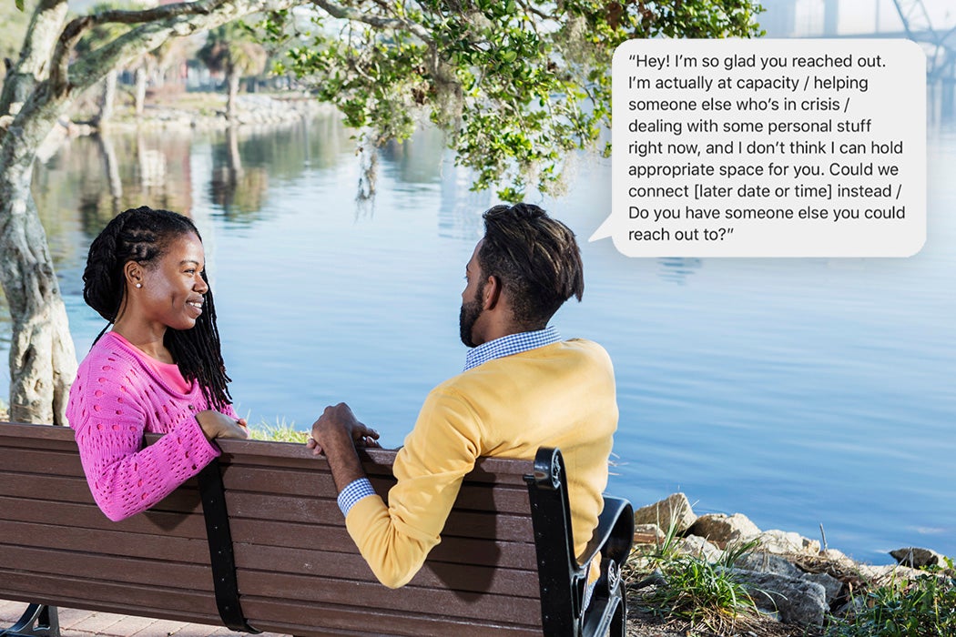 A mid adult couple in their 30s sitting on a park bench overlooking a city waterfront. The woman is African-American and the man is mixed race African-American and Hispanic. They are conversing face to face.