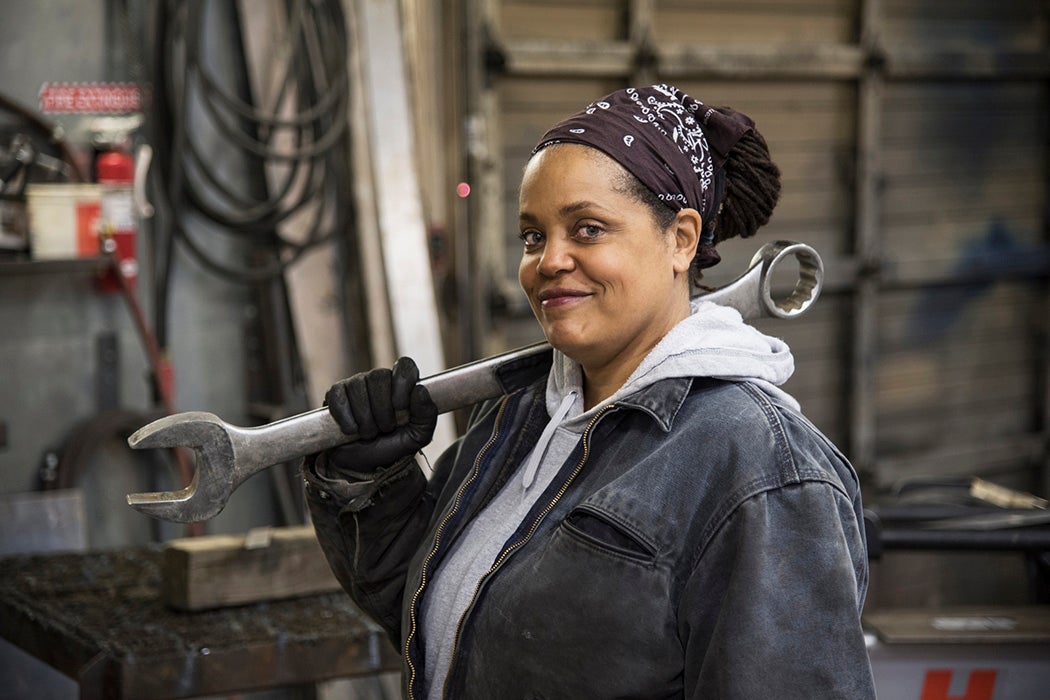 An African American worker carrying a tool in a factory