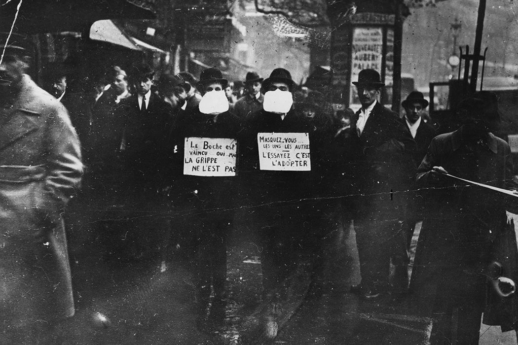 Two men wearing and advocating the use of flu masks in Paris during the Spanish flu epidemic, 1919