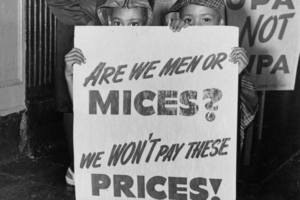 Two young children holding placard which reads "Are we men or mices? We won't pay these prices" at a demonstration in Harlem between the 116th and the 125th to protest against housing conditions and rent price, New York City, US, July 1946.