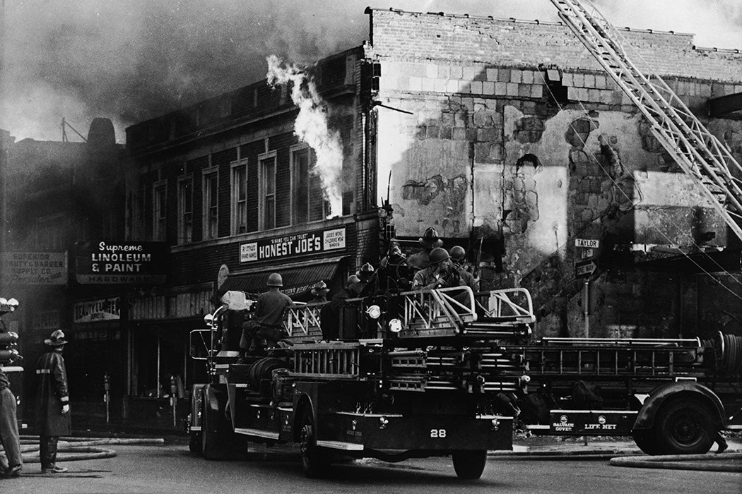 Federal troops ride on a fire engine to protect the firefighters from snipers during the riots in Detroit, Michigan, July 27, 1967