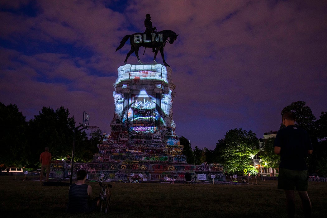 George Floyd's image is projected on the Robert E. Lee Monument as people gather around on June 18, 2020 in Richmond, Virginia.