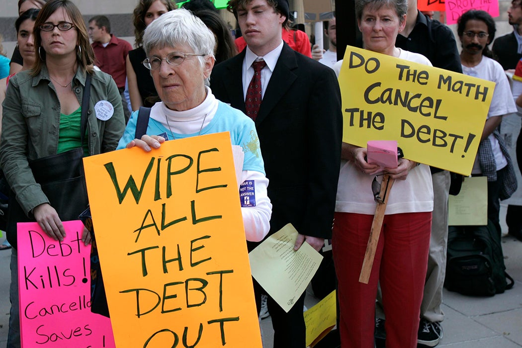 Miriam Bauerlin holds a sign pleading for debt cancelation during a protest near the US Treasury Department October 1, 2004 in Washington, DC.