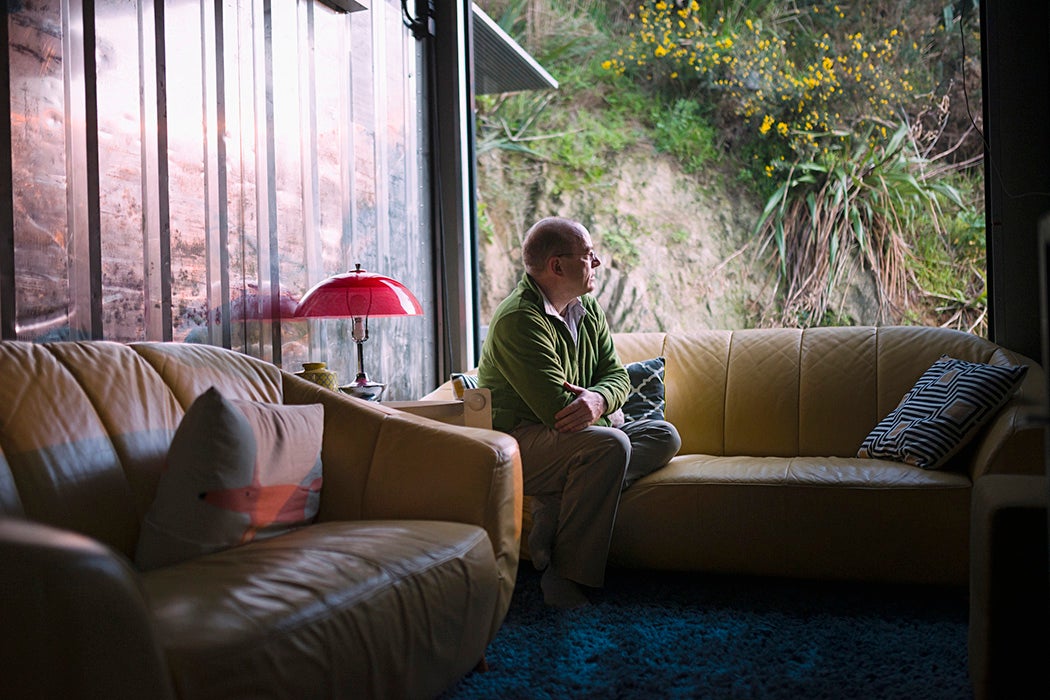 Pensive Caucasian man sitting on sofa near window