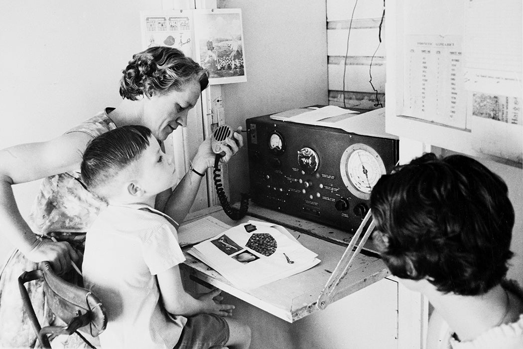 Primary student in regional Queensland takes class via two way radio from Australia's School of the Air, c 1960