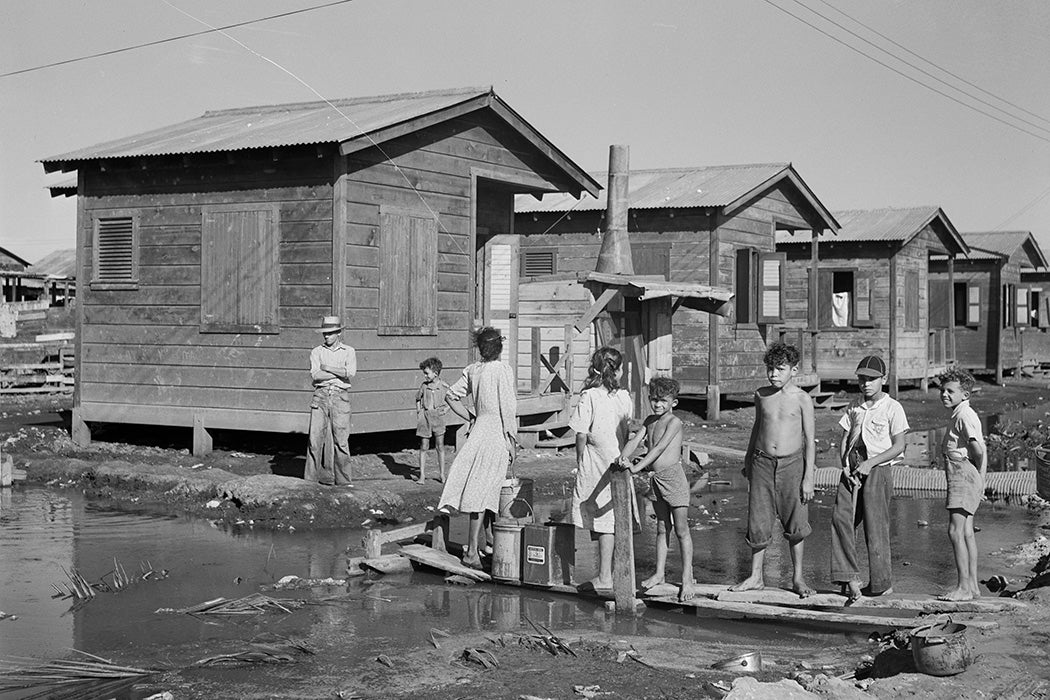 Fetching water from a spigot which services many people who live in the huge slum area known as "El Fangitto" in San Juan, Puerto Rico