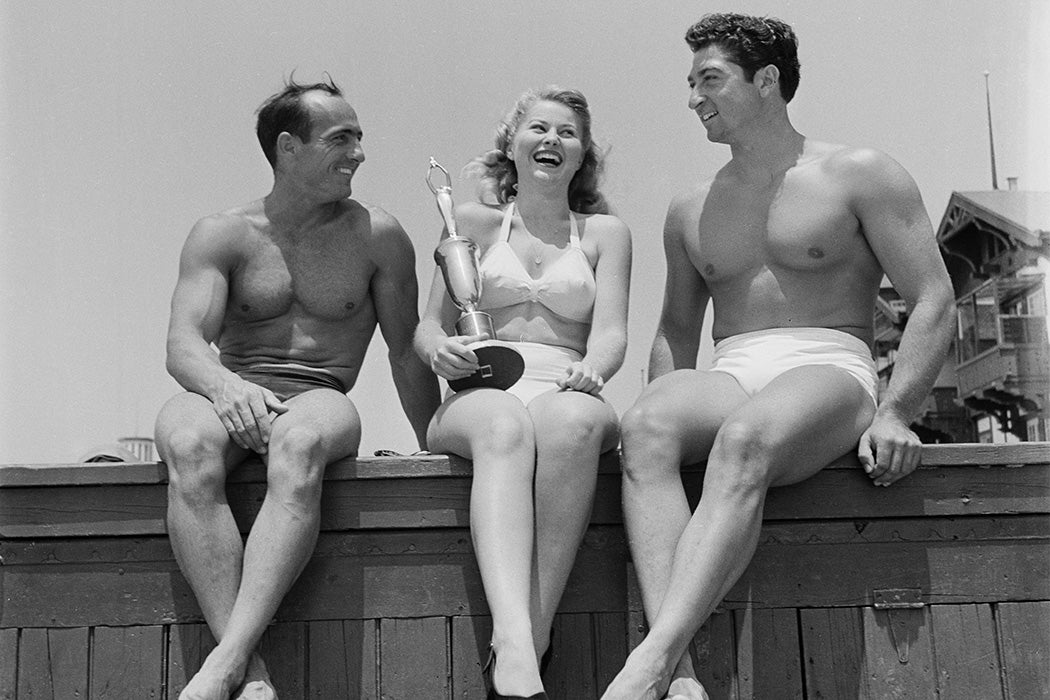 Three muscle builders pose at Muscle Beach on the Santa Monica Beach in California, 1949