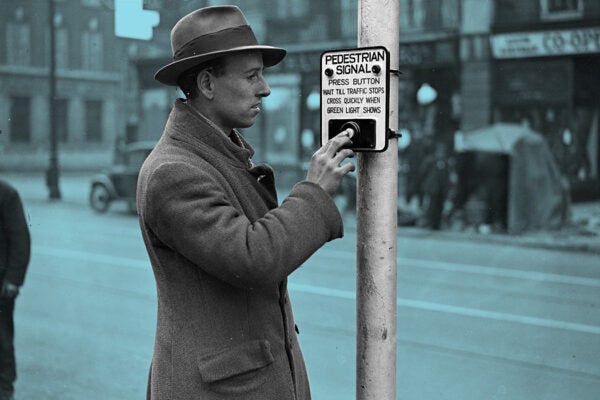 A pedestrian uses the press-button system in order to cross the road in Croydon, London, 1932