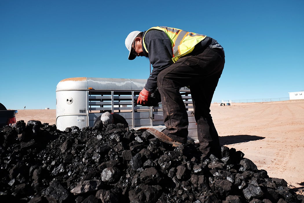 A Navajo Nation volunteer collects coal to distribute to Native Americans in need at a free wood collection site on December 17, 2021 in Tuba City, Arizona.