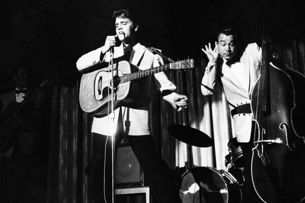 Elvis Presley singing on stage with Bill Block, circa 1950s.