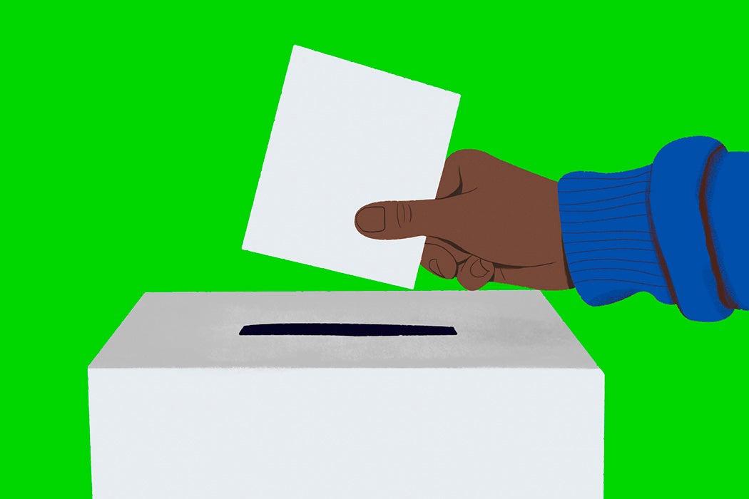 Close up hand of voter placing ballot in ballot box